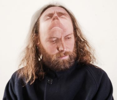 A photograph of performer Rob Auton with two faces.