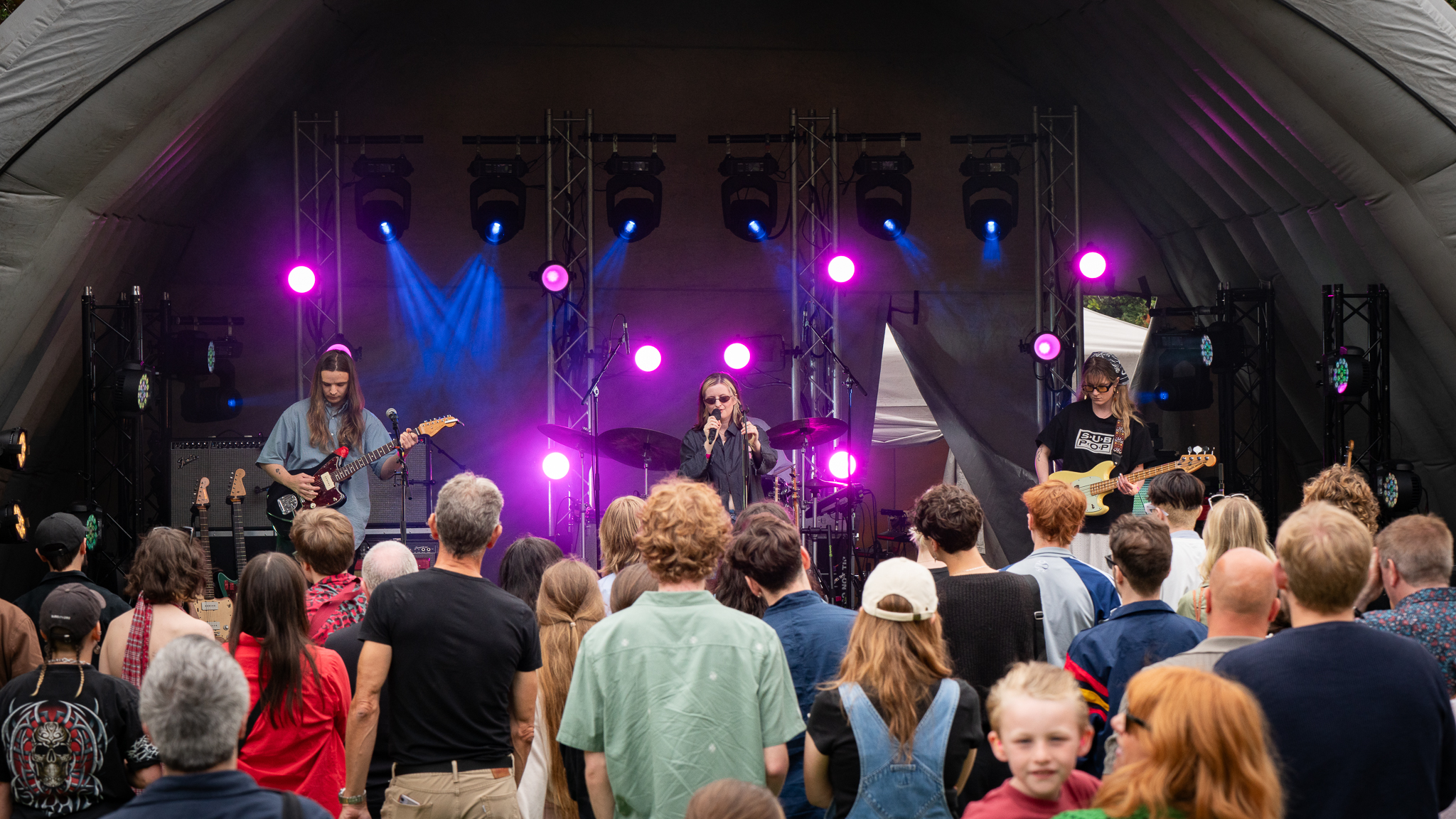 A photograph of the band Theo Bleak on stage performing to an audience.