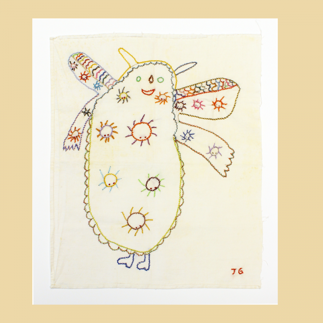 whimsical embroidery on white fabric featuring a large, central, cloud-like creature with small, multi-colored spiders stitched across its body, with the artist's initials 'JG' in the bottom right corner.