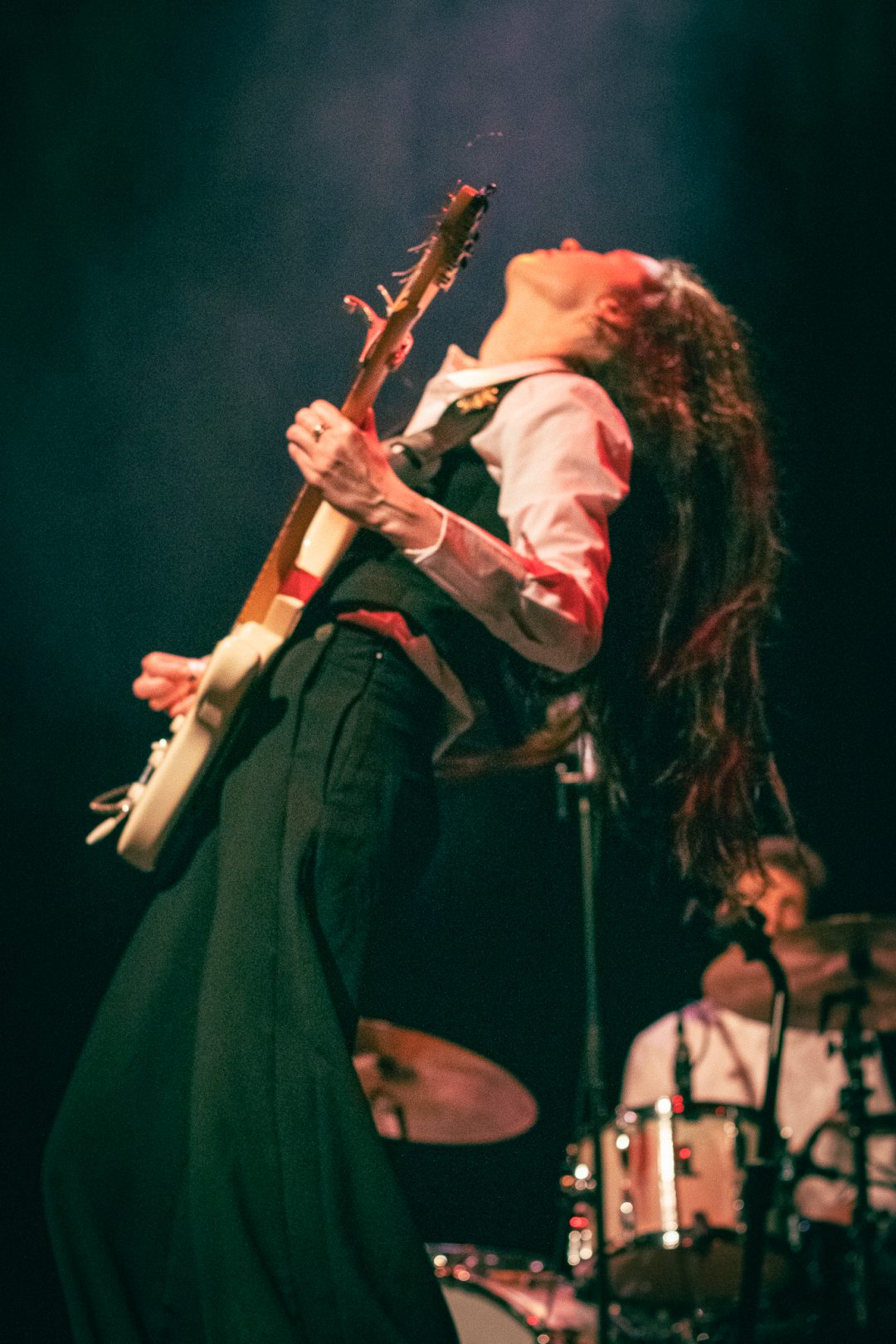 Frankie Morrow plays live on stage with a guitar.