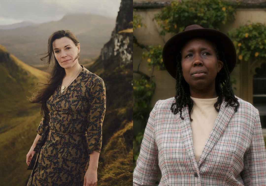 Cal Flyn with long dark hair and a patterned dress outdoors in a landscape with rolling hills, alongside J C Niala wearing a tweed jacket, white top, and brown fedora hat.