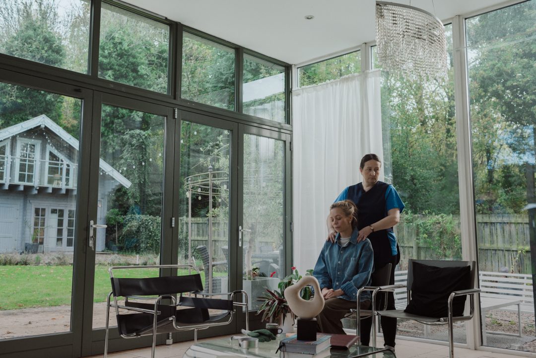 Still from Bubbles showing a person receiving a shoulder massage inside a glass-walled room.