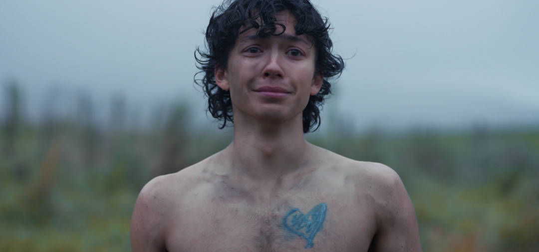 Still from My Little Blue Heart showing a young man with a blue heart painted on his chest.