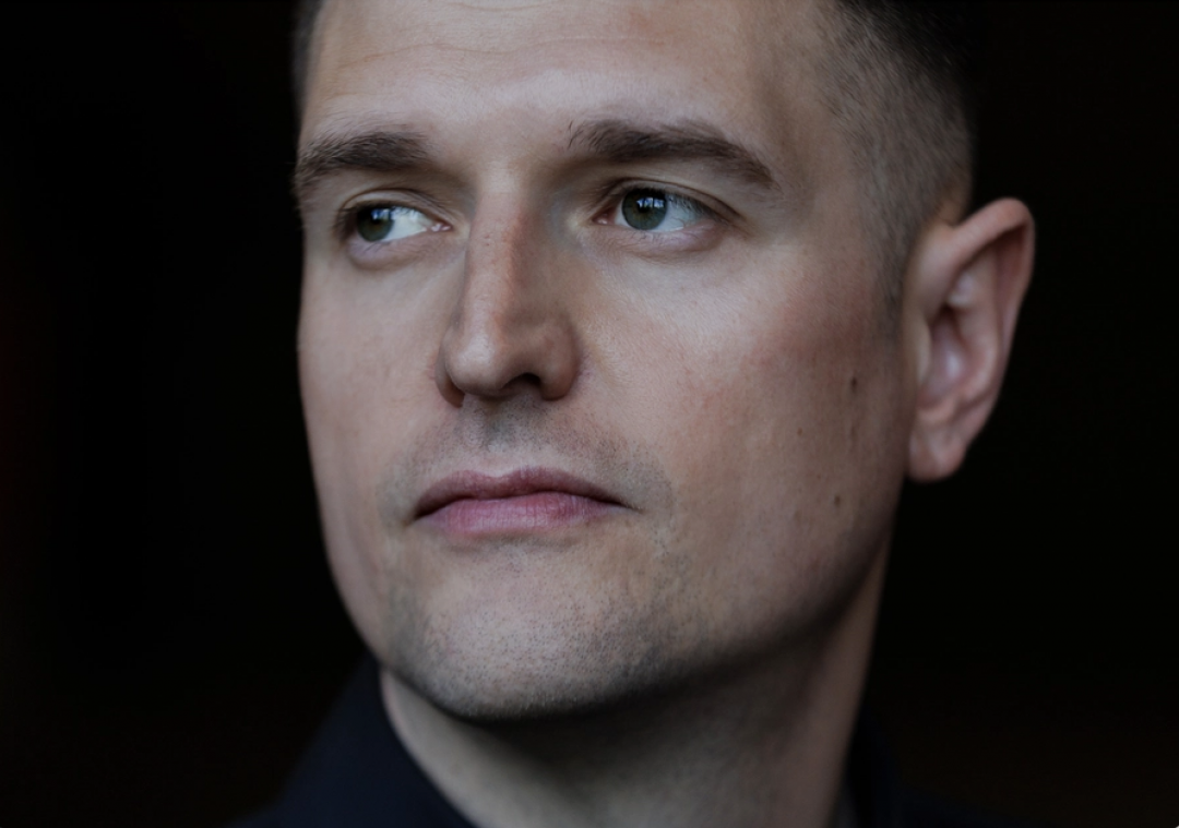 Close-up profile portrait of Graeme Armstrong with short dark hair looking off to the side against a dark background.