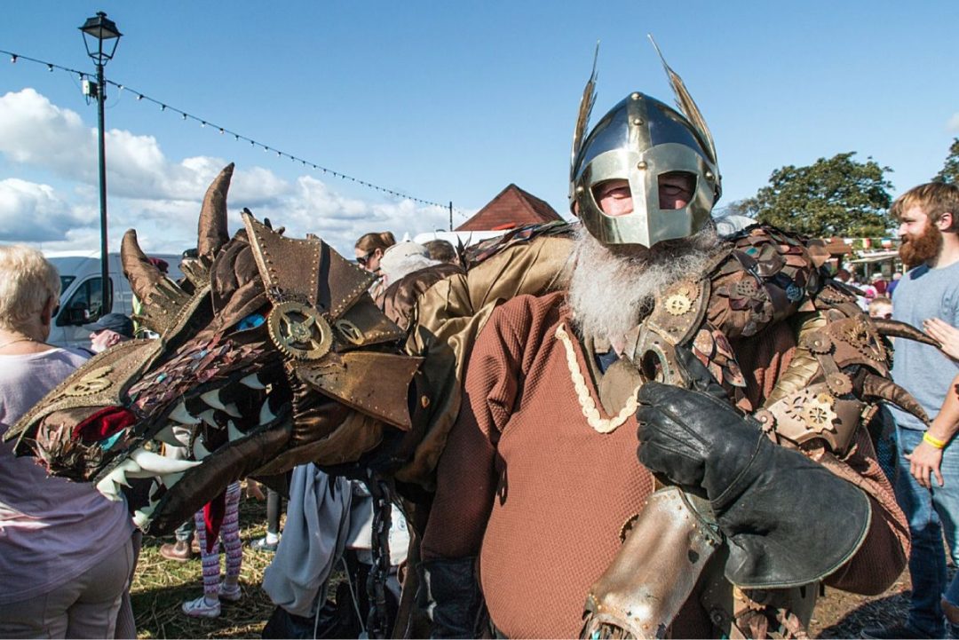 Performer dressed in Viking costume with a horned helmet and a mechanical dragon prop, capturing one of the top Edinburgh Fringe alternatives