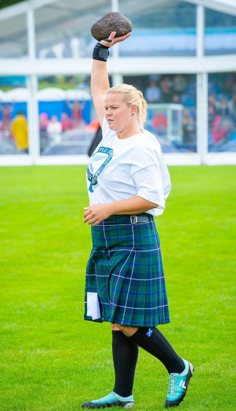 Competitor wearing a tartan kilt tossing the heavy stone at the Cowal Highland Gathering, a top Edinburgh Fringe alternative