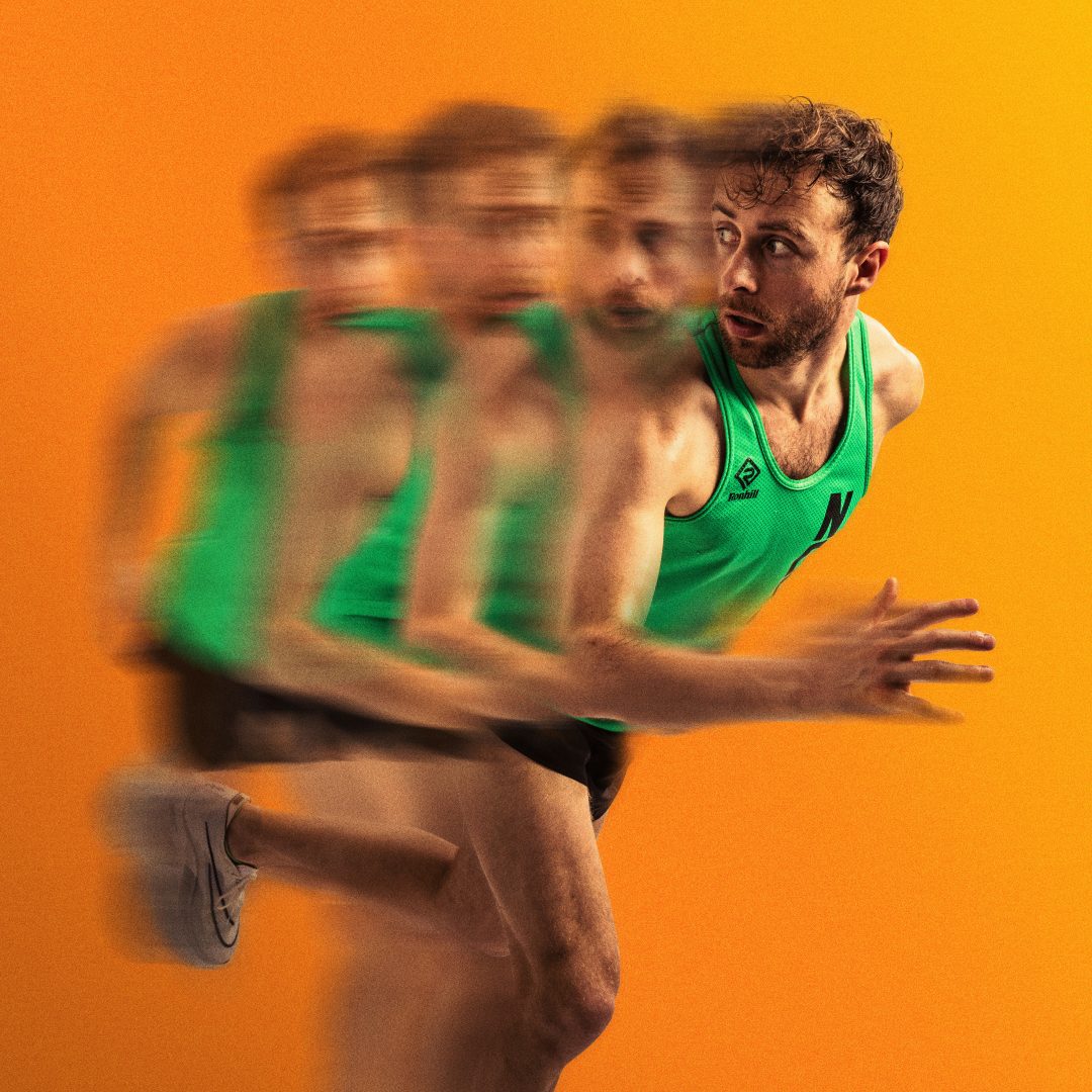 A promotional image for The Distance featuring a runner in a green vest with motion-blur effects against an orange background.