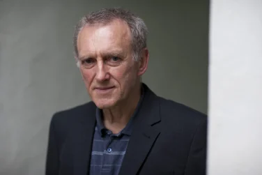 Photo of James Kelman headshot on grey background
