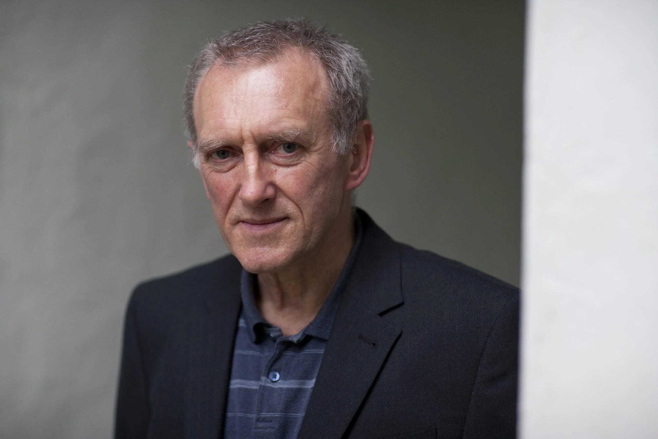 Photo of James Kelman headshot on grey background